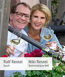Zwei Personen stoßen mit Wein