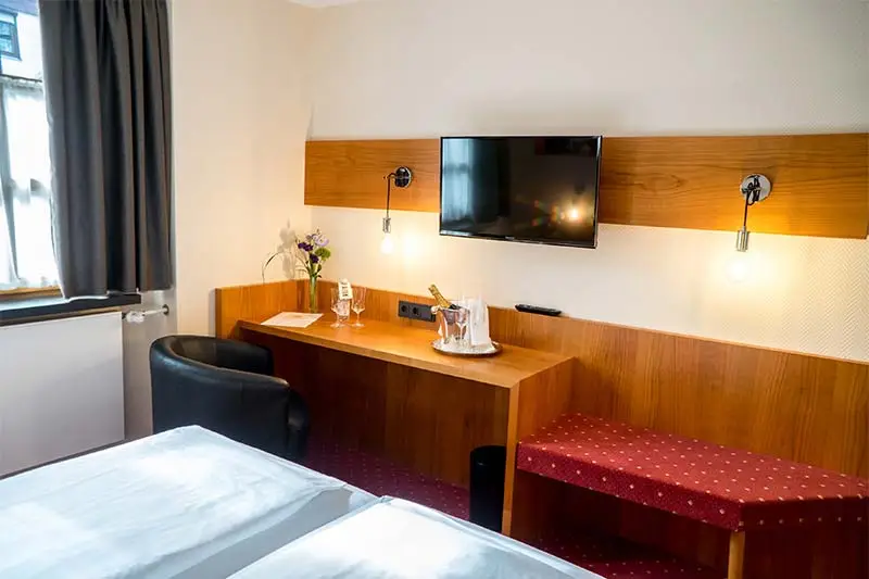 Hotelzimmer mit Schreibtisch, TV und Sessel
