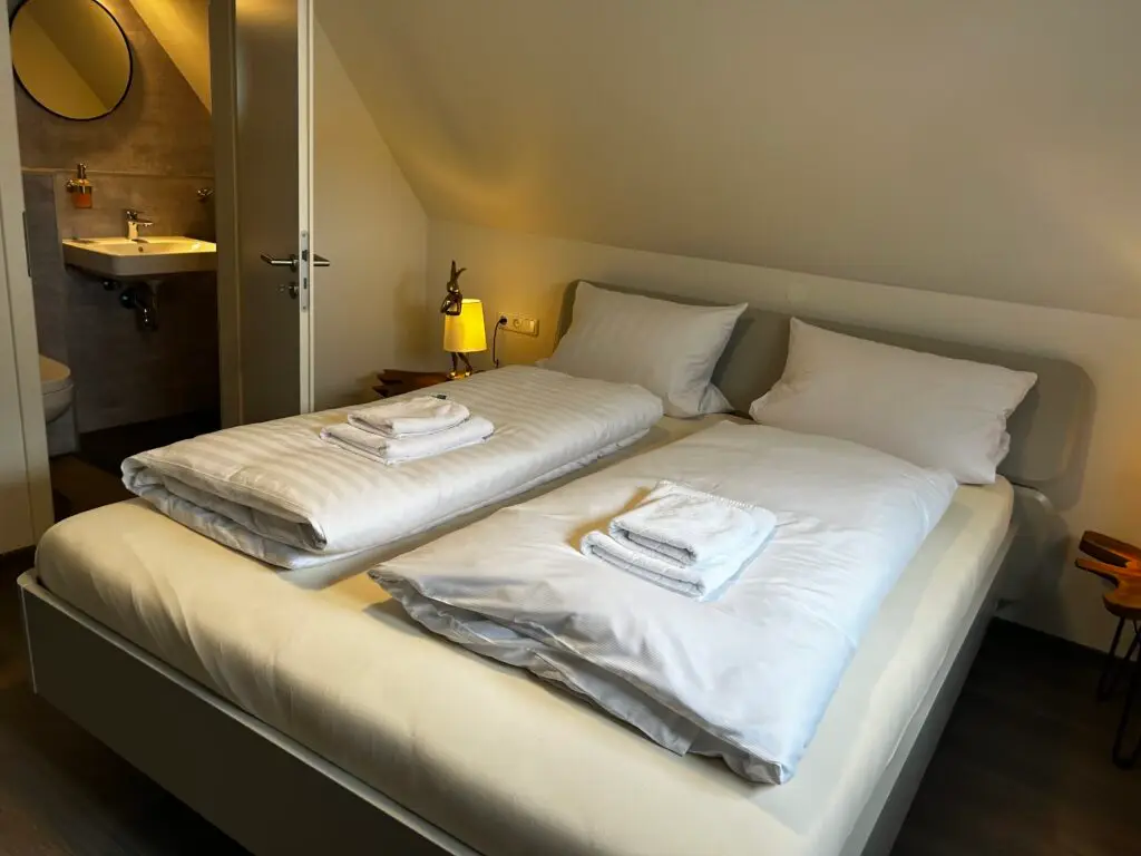 Dachzimmer mit hellgrauem Doppelbett