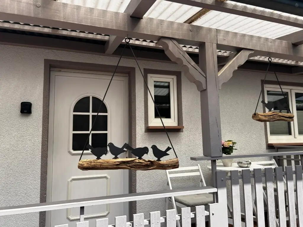 Balkon eines Fachwerkhauses mit Bank und Fenstern